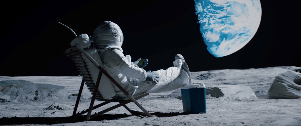 lunar astronaut having a beer sitting in a beach chair with cooler